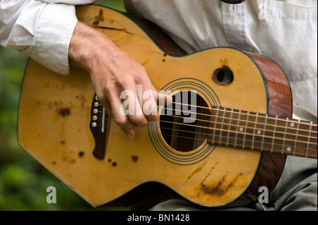 Camping musicisti suonare la chitarra e cantare una melodia in Redwoods Foto Stock