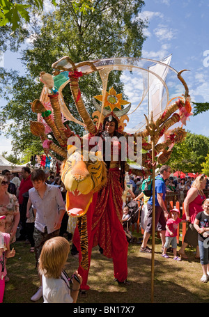 Stilt-walking attore raffigurante la dea Indù Durga, passeggiate attraverso la folla di attrarre un pubblico; Glasgow Mela 2010 Foto Stock