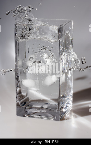 Cubetti di ghiaccio cade in un vaso di acqua Foto Stock