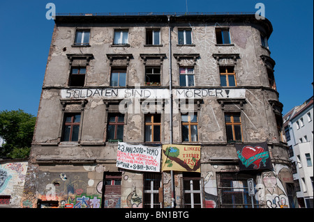 Il vecchio edificio di appartamenti con squatter vivere all'interno della protesta e Banner appesi sulla parete in Mitte Berlino Germania Foto Stock