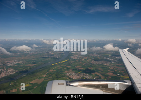 Vista attraverso il finestrino di un aereo commerciale con il paesaggio e le piccole soffici nuvole in vista, Europa 2010 Foto Stock