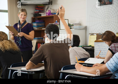 Studente alzando la mano in classe Foto Stock