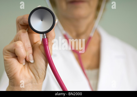 Medico con stetoscopio in preparazione per dare medical exam Foto Stock