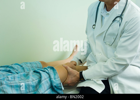 Medico esaminando gamba del paziente Foto Stock