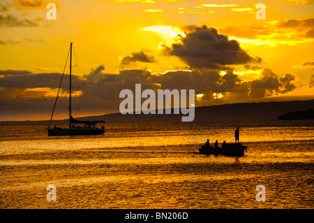 Traghetti e yacht in un porto durante un bel colore arancione tramonto. Foto Stock