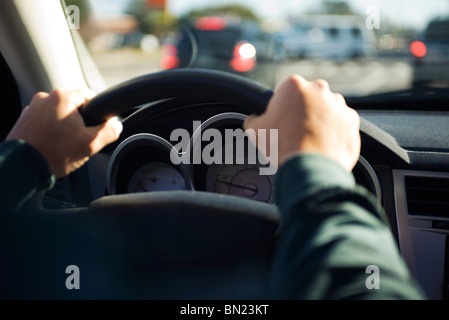 La guida con entrambe le mani sul volante Foto Stock