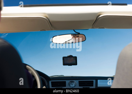 Donna alla guida di auto e la riflessione in specchietto retrovisore Foto Stock