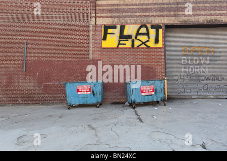 2 cassonetti di fronte ad un garage chiuso la porta sotto piatto segno fisso. Foto Stock