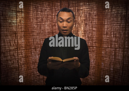 Pacific Islander sacerdote leggendo la Bibbia Foto Stock