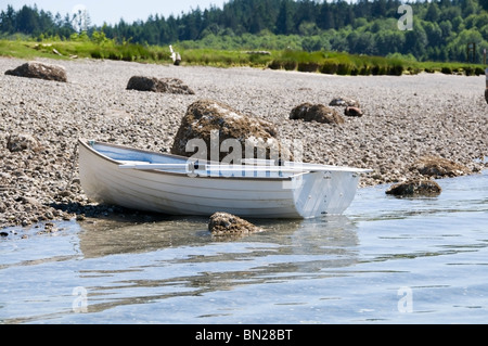 Un dinghy non occupato si appoggia sulla riva McMicken Island State Park mentre il proprietario esplora l'isola con la bassa marea. Foto Stock