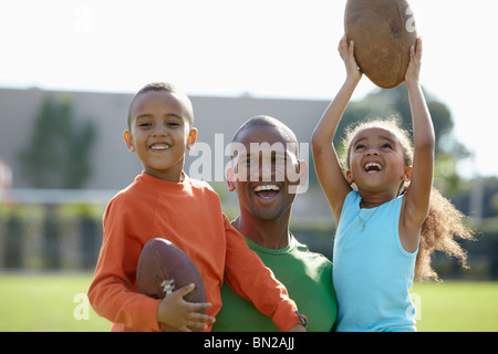 Americano africano il padre, il figlio e la figlia a giocare il gioco del calcio Foto Stock
