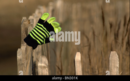 Perso il guanto sulla recinzione Foto Stock