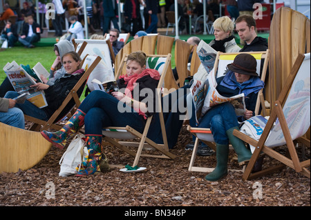 Le persone la lettura di libri e giornali in seduta sdraio a Hay Festival 2010 Hay on Wye Powys Wales UK Foto Stock