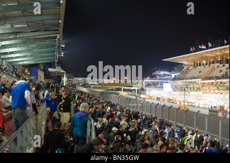 Gli spettatori a guardare il box al 2010 Le Mans 24 ore di gara durante la notte Foto Stock