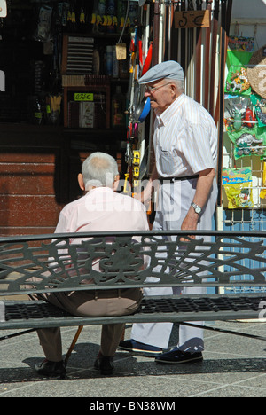 Anziani spagnolo uomini seduti su una panchina in Calle Virgen de la Paz, Medina Sidonia, la provincia di Cadiz Cadice, Andalusia, Spagna, Europa. Foto Stock