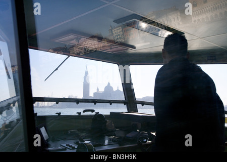 Driver della barca, San Giorgio Maggiore in background, Venezia, Italia Foto Stock