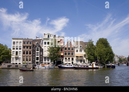 Gli edifici del waterfront del fiume Amstel, Amsterdam, Paesi Bassi Foto Stock