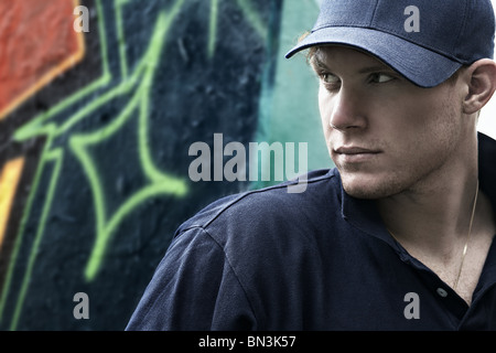 Giovane uomo di pensiero nella parte anteriore del muro di graffiti Foto Stock