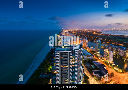 Guardando a Sud di alta crescita, Collins Avenue e Oceano Atlantico al crepuscolo, Miami Beach, Florida, Stati Uniti d'America Foto Stock