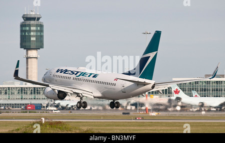 Un Westjet Boeing 737-700 aereo jet atterraggio all'Aeroporto Internazionale di Vancouver (YVR). Foto Stock