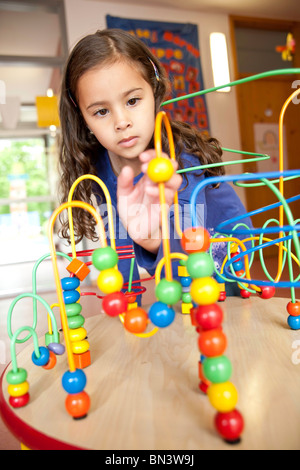 Giovane ragazza che gioca con un giocattolo educativo Foto Stock