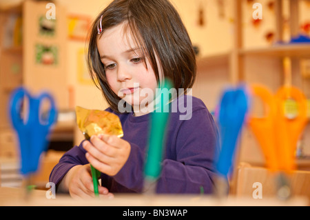 Bambina con le forbici per tagliare la carta e a basso angolo di visione Foto Stock