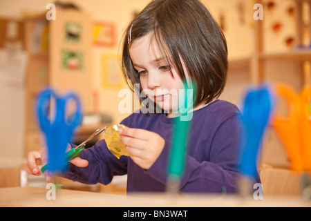 Bambina con le forbici per tagliare la carta e a basso angolo di visione Foto Stock