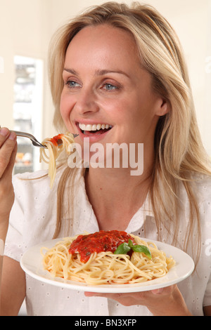 Donna mangiare pasta Foto Stock