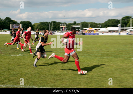 Un winger sfugge alla difesa nel rugby a sette il gioco, Richmond Rugby Club, Surrey, Regno Unito. Giugno 2010 (alcune sfocature) Foto Stock