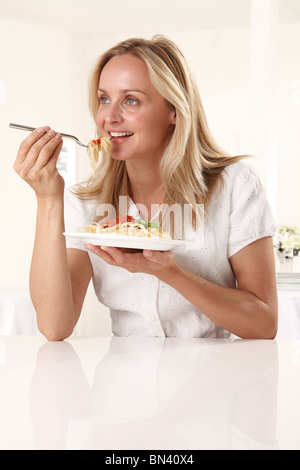 Donna mangiare pasta Foto Stock