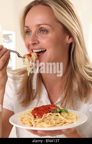 Donna mangiare pasta Foto Stock