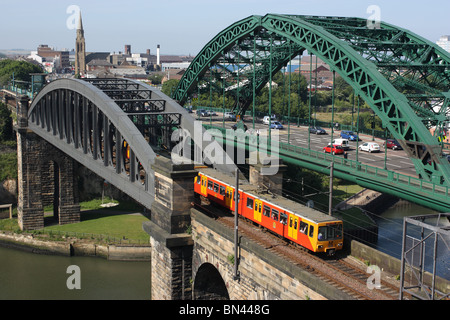 A Tyne and Wear Metro treno capi sud oltre il Wearmouth ponte ferroviario a Sunderland, England, Regno Unito Foto Stock
