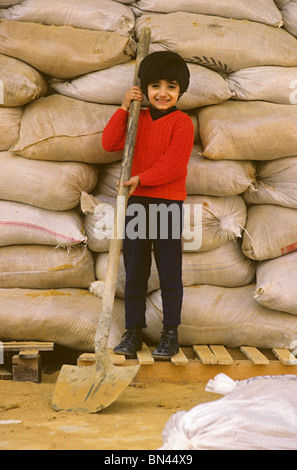 Bambino di fronte all ingresso di un edificio protetto da sacchi di sabbia durante la guerra civile nel 1988 Beirut Libano Foto Stock