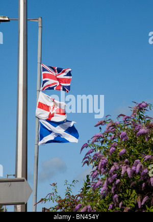 Tre bandiere: la bandiera europea (Jack), Ulster banner e si intraversa scozzese, che simboleggia loyalism / sindacalismo, volare da una fila di sabbia lampione a Belfast Foto Stock