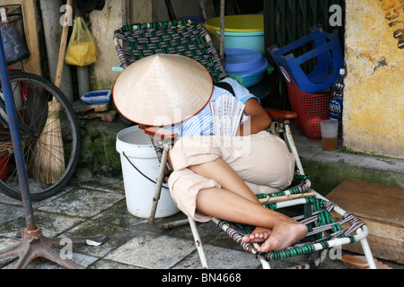 Il vietnamita donna che dorme in una strada ad Hanoi, Vietnam. Foto Stock