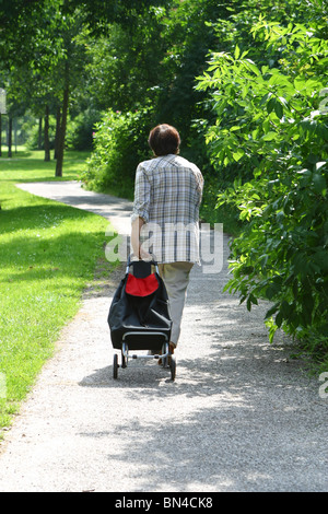 Vista posteriore donna vecchia a piedi in posizione di parcheggio Foto Stock