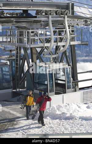 Gli appassionati di snowboard lasciando funivie in località sciistica Alpi Svizzere. Foto Stock