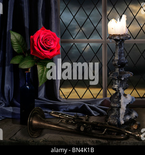 Sorse su una guarnizione finestrino lite da una candela con una vecchia tromba con cielo scuro Foto Stock