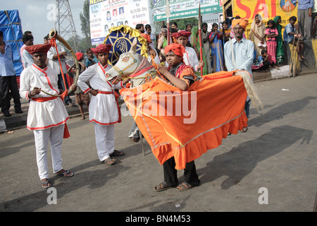 Kachi Ghodi; gli uomini in piedi nel cavallo fittizia esecuzione Ranjasthani danza indossando il costume maratti durante la processione religiosa Foto Stock