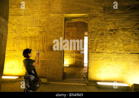 Una femmina di turisti fotografare i geroglifici e intagli in rilievo all'interno del Tempio di Horus in Edfu, l'Alto Egitto Foto Stock