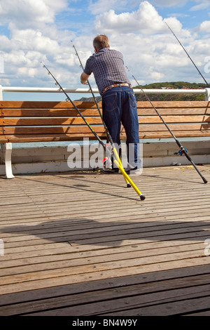 Un pescatore di mare pesca al largo Cromer Pier Foto Stock