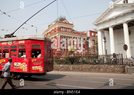 Il tram passa la chiesa di S. Andrea e il rosso degli edifici di scrittori in Kolkata (Calcutta), West Bengal, India. Foto Stock