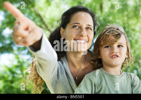 Madre sottolineando qualcosa al giovane figlio all'aperto Foto Stock