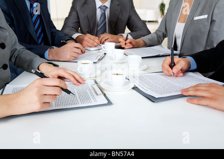 Immagine della gente di affari le mani con ballpoints la scrittura su carte mentre i lavori di pianificazione Foto Stock