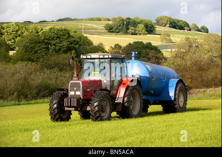 Lo spandimento di liquame con una petroliera vuoto sul retro di un Massey Ferguson 6180 Foto Stock