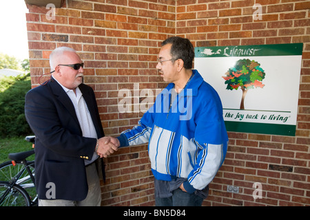 Parole officer visitando parolee nel campo. Il check in e assicurandosi che il parolee è in grado di soddisfare le esigenze di parole. Foto Stock