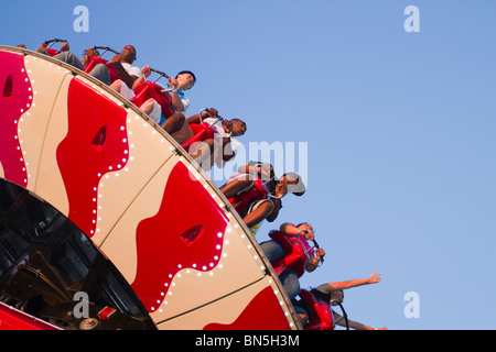 I visitatori potranno gustarsi le emozionanti Electro Spin ride presso la nuova luna park di Coney Island al tramonto Foto Stock