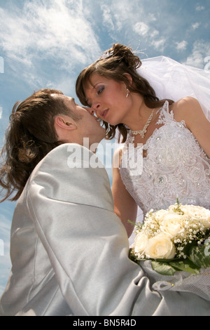 Lo sposo e la sposa abbracciare su uno sfondo di cielo blu scuro. Foto Stock