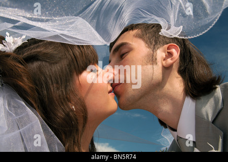 Lo sposo e la sposa abbracciare su uno sfondo di cielo blu scuro. Foto Stock