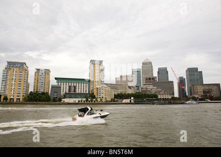 Una barca a motore sul fiume Tamigi, vicino a Canary Wharf a Londra, Inghilterra, Regno Unito. Foto Stock